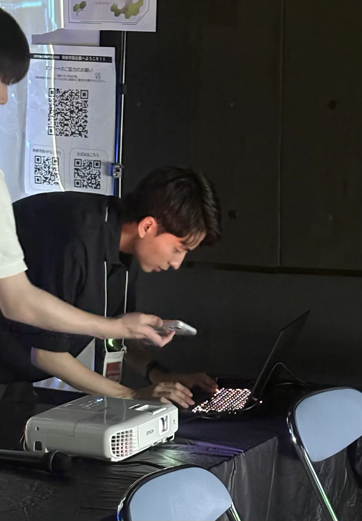 イベント会場でプロジェクターとPCを操作する遠藤悠斗